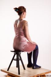 Sitting reference of whole body pink dress purple tights black shoes Nadine